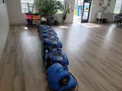 Row of air movers drying a vinyl plank floor after water damage in O'Fallon, MO