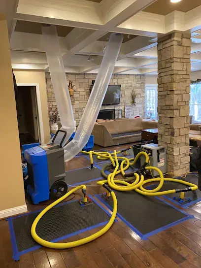 Dehumidifier and floor drying mats under containment in an O'Fallon living room