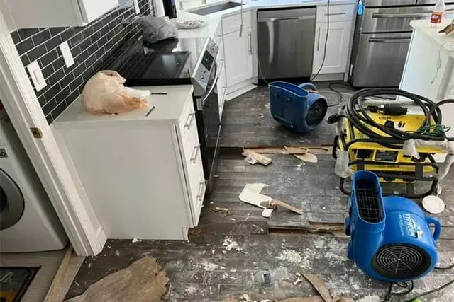 Kitchen with flooring removed and drying equipment running in O'Fallon