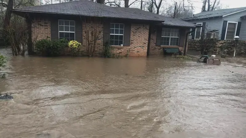 Flash floodwater surrounding a brick ranch house after a heavy Missouri storm